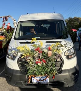 Minibus with Australian flowers attached to the front of the bus in a decorative way.
